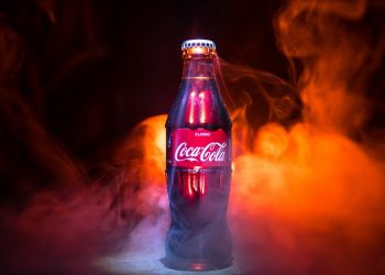 Baku, Azerbaijan 13th January 2018, Coca-Cola Classic in a glass bottle on dark toned foggy Background. Coca Cola, Coke is the most popular carbonated soft drink beverages sold around the world