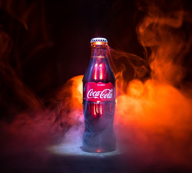 Baku, Azerbaijan 13th January 2018, Coca-Cola Classic in a glass bottle on dark toned foggy Background. Coca Cola, Coke is the most popular carbonated soft drink beverages sold around the world